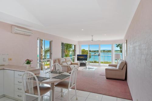 a kitchen and living room with a table and chairs at Beach Street Apartments in Merimbula