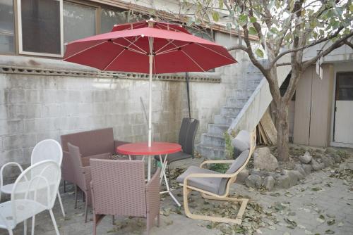 a red table and chairs with a red umbrella at Wonju Aunt Home in Wonju