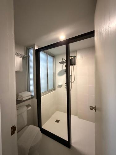 a bathroom with a toilet and a large mirror at Kitzio House Hotel Huai Kwang in Ban Na Song