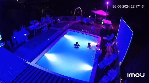 dwie osoby bawiące się w basenie nocą w obiekcie Apartment STONE w mieście Visoko
