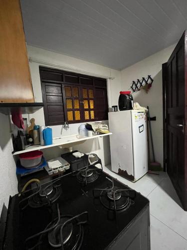 a kitchen with a stove and a white refrigerator at Casa Simples e Charmosa na Praia de Ipioca in Maceió