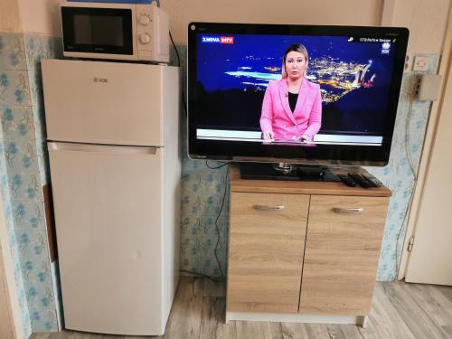 a flat screen tv sitting on top of a refrigerator at Small house in Celje in Celje