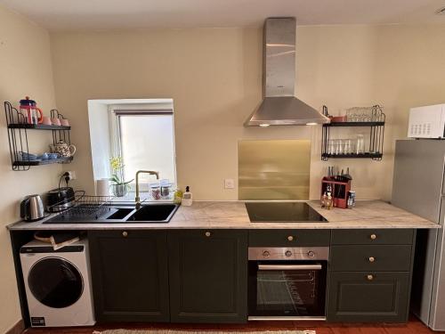 une cuisine avec un évier et une cuisinière dans l'établissement Charmante maison au cœur de Chtx-cour privée-clim, à Châteauroux