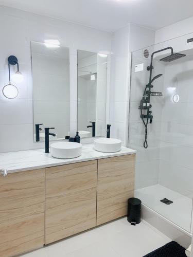 une salle de bain avec deux lavabos et un grand miroir dans l'établissement Appartement avec une place de parking, à Hendaye