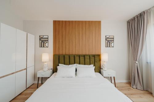 a bedroom with a large white bed with two night stands at Lavender Nest 6 - Hiperbara - Livezeni - 2BR in Livezeni