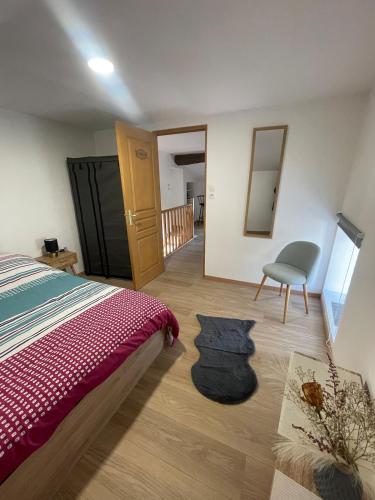une chambre avec un lit, une chaise et un miroir dans l'établissement Warm home, à Madonne-et-Lamarey