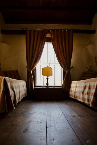 a room with a window with curtains and a lamp at Azienda Agricola Mandranova in Palma di Montechiaro