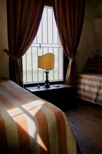 a bedroom with a bed and a window with a lamp at Azienda Agricola Mandranova in Palma di Montechiaro