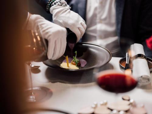 a person preparing a plate of food on a table at Geinberg5 Private Spa Villas in Geinberg
