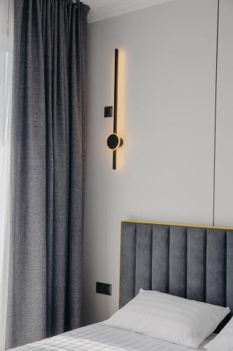 a bedroom with a bed with a gray curtain at Апарт-отель Tong Marina in Tong