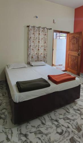 a large bed in a room with a red blanket on it at Vasavi Family Stay Hampi in Hampi