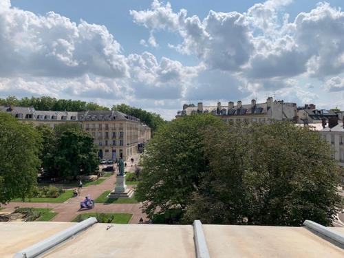 - une vue sur une ville avec des bâtiments et une statue dans l'établissement Au pied du Château, à Versailles