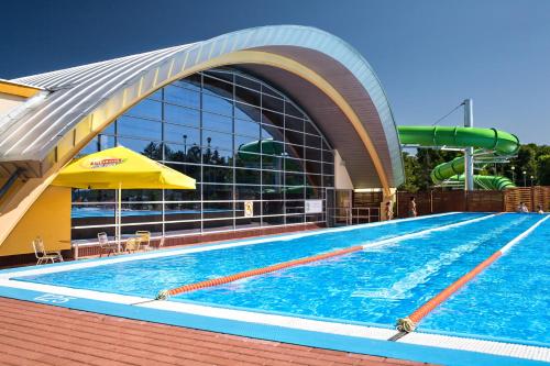 una piscina di fronte a un edificio di GRANO APARTHOTEL Ustronie Morskie a Ustronie Morskie