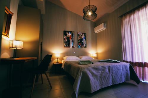 a bedroom with a bed and a desk and a window at Κομψό διαμέρισμα κοντά σε όμορφη παραλία in Hanioti