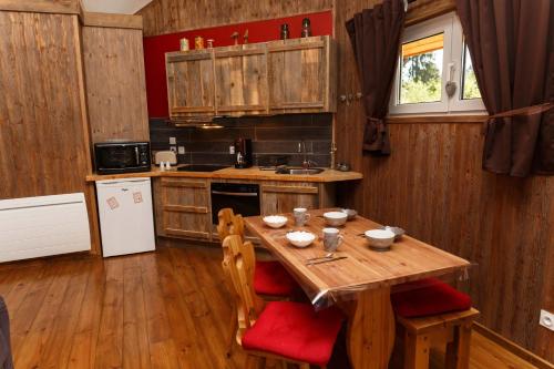 une cuisine avec une table en bois et des chaises rembourrées dans l'établissement Domaine De Siane, à Plaine