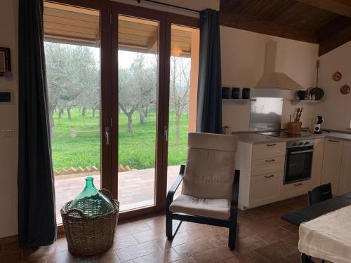 a kitchen with a table and a chair and a window at La stalla di nonno Zopito casa vacanze in Loreto Aprutino