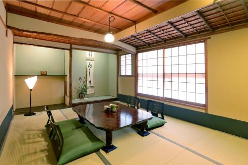 a room with a table and chairs and windows at Mitsuki Kyoto in Kyoto