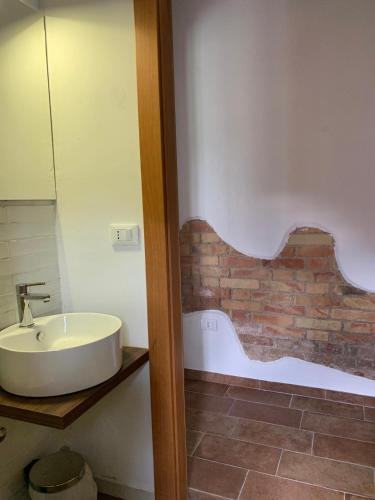 a bathroom with a sink and a brick wall at La stalla di nonno Zopito casa vacanze in Loreto Aprutino