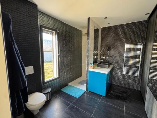 une salle de bain avec toilettes, lavabo et fenêtre dans l'établissement Villa des mazes, à Vallon-Pont-dʼArc