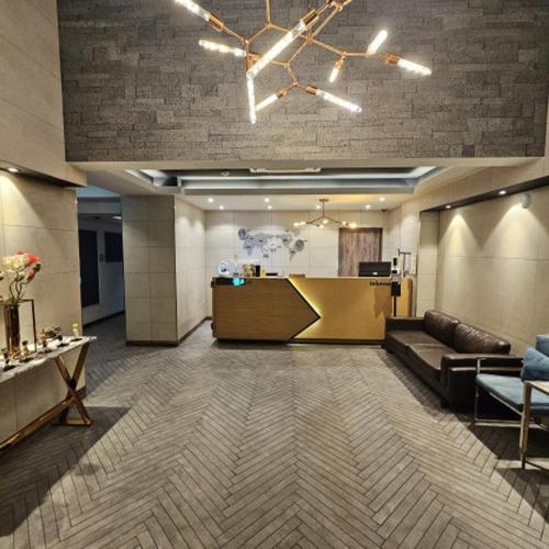 a lobby with a couch and a reception desk at Louis Hotel in Gangneung