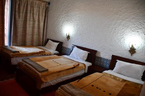 a room with three beds in a room at Hôtel Rose Mgouna in Kalaat MGouna