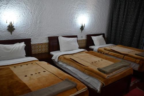 a room with three beds in a room at Hôtel Rose Mgouna in Kalaat MGouna