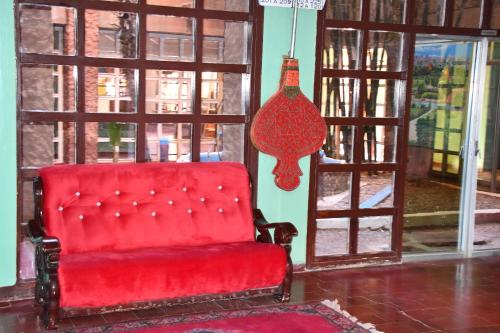 a red chair sitting in front of a window at Hôtel Rose Mgouna in Kalaat MGouna