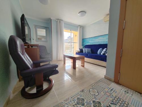 a living room with a chair and a couch at Tout près de la plage in Puerto de Sagunto