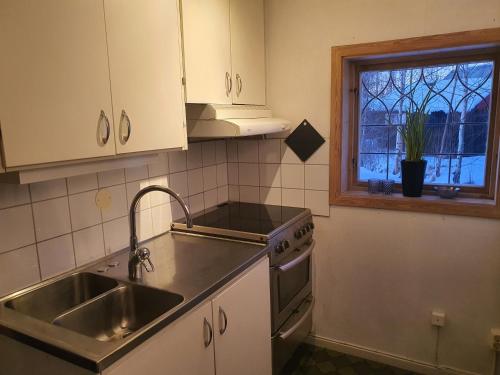 a kitchen with a sink and a stove and a window at Mora Life, Åmåsängsgården in Mora