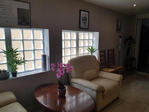 a living room with a couch and a table and windows at Entire apartment 62 m2 3 rooms 1st floor in Bezons