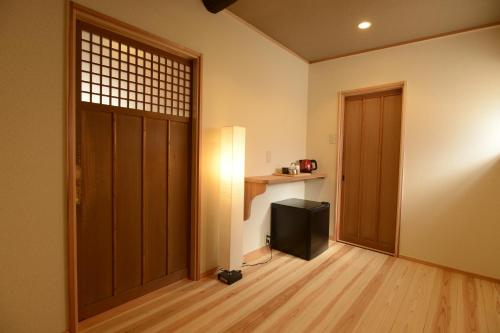 a room with a door and a television in it at Mitsuki Kyoto in Kyoto