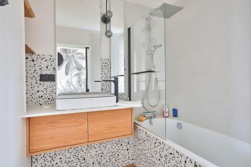 une salle de bain avec un lavabo, un miroir et une baignoire dans l'établissement Superb 1BR flat on the Bois Blancs district, à Lille