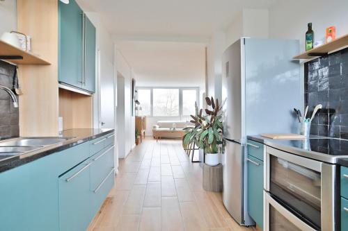 Il comprend une cuisine avec des placards bleus et du carrelage. dans l'établissement Superb 1BR flat on the Bois Blancs district, à Lille