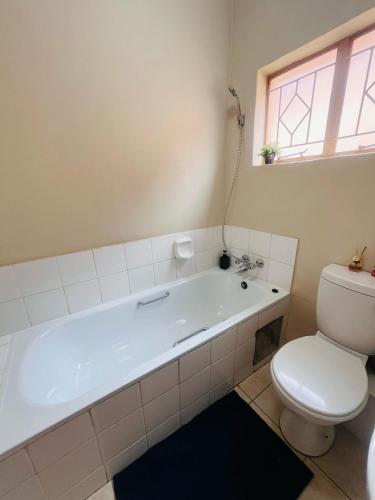 łazienka z białą wanną i toaletą w obiekcie R&R Stays w mieście Gaborone