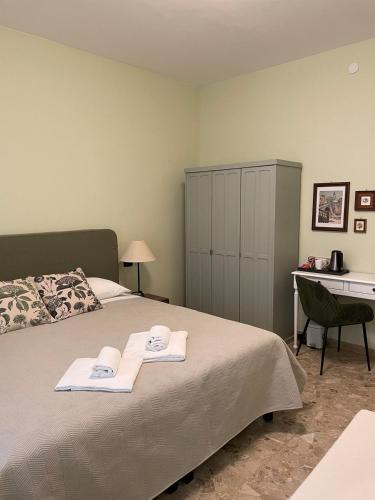 a bedroom with a bed with two towels on it at Arena Rooms in Verona