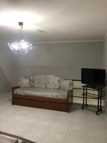 a room with a bed and a television and a chandelier at Casa di Codo in Naples