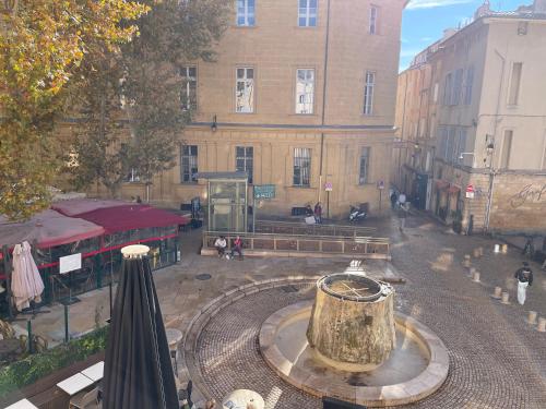 un bâtiment avec une fontaine au milieu d'une rue dans l'établissement Studio climatisé plein centre ville 1er ETAGE, à Aix-en-Provence