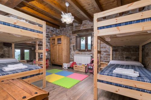 two bunk beds in a room with wooden ceilings at Cabaña Pasiega El Ojal B in San Pedro del Romeral