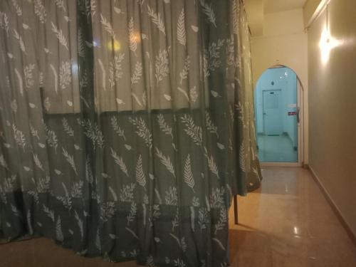 a room with a curtain and a hallway at มังกรเลโฮสเทล Mangkonlay Hostel in Ban Khlong Pak