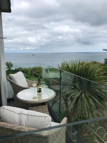 a balcony with a table and a view of the ocean at Mevagissey Boutique Flatlet with sea and countryside views in Mevagissey