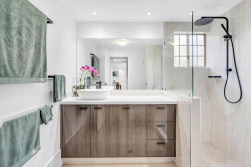 ein Badezimmer mit Waschbecken und Dusche in der Unterkunft 2BR The Lakes Resort Escape, 4 Pools 5 min Airport in Cairns North