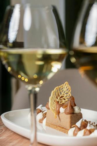 a plate with a piece of dessert and a glass of wine at Sheraton Paris Charles de Gaulle Airport Hotel in Roissy-en-France