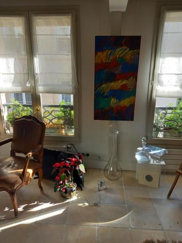 un salon avec une chaise et un tableau mural dans l'établissement Duplex Terrasse cœur de Paris Montorgueil, à Paris