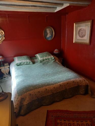 - une chambre avec un lit dans un mur rouge dans l'établissement Duplex Terrasse cœur de Paris Montorgueil, à Paris