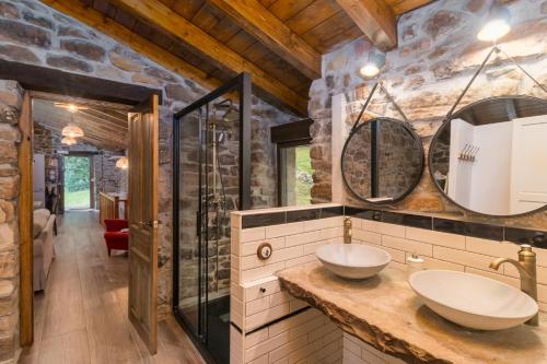 a bathroom with two sinks and a glass shower at Cabaña Pasiega El Ojal B in San Pedro del Romeral