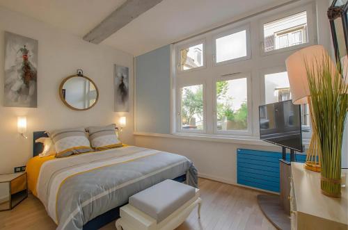 une chambre avec un lit, une télévision et des fenêtres dans l'établissement Superbe appartement au coeur de Troyes, à Troyes