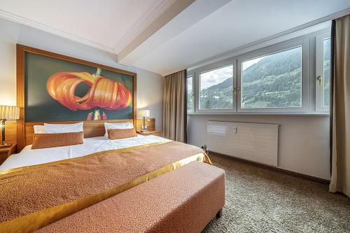 a bedroom with a bed with a pumpkin painting on the wall at EUROPÄISCHER HOF Bad Gastein in Bad Gastein