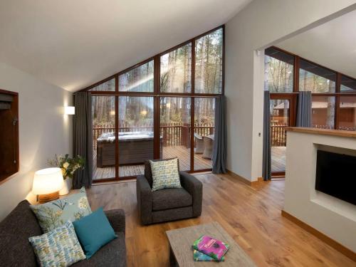 a living room with a couch and a fireplace at Forest of Dean Cabins - Forest Holidays in Staunton