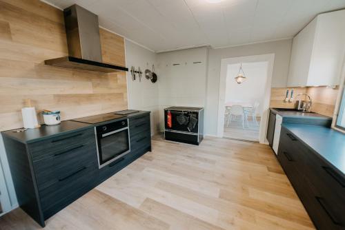 a kitchen with black cabinets and a wooden floor at Holiday home in the middle of nature in Kemijärvi