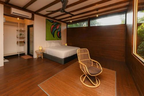 a bedroom with a bed and a chair in it at The HIJAU Camp & Cabin in Gopeng